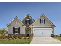 Charming home featuring a mix of stone and siding, complemented by a two-car garage and well-manicured lawn at 103 White Apple Way, Statesville, NC 28625