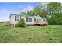 Charming single-story home with a wooden deck and lush green lawn at 125 Rocky Pt, Cleveland, NC 27013