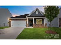 Charming single-Gathering home with a two-car garage, stone accents, manicured lawn, and welcoming front porch at 1335 Secrest Commons Dr, Monroe, NC 28112
