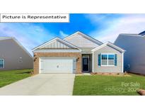 Charming single-Gathering home with a brick and vinyl exterior, well-manicured lawn, and two car garage at 1349 Secrest Commons Dr, Monroe, NC 28112