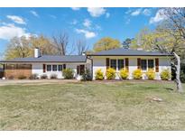 Charming home featuring well-manicured lawn, complemented by colorful shrubs and classic shutters against a bright, sunny sky at 1467 Alexander Rd, Rock Hill, SC 29732