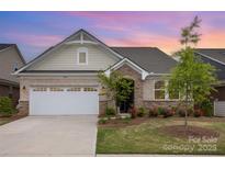 Charming single-story home with brick and stone accents, attached garage, and beautifully landscaped front yard at 3618 Marchers Trace Dr, Mint Hill, NC 28227