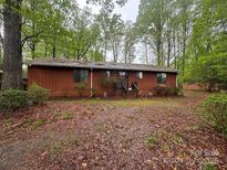 Charming single-story home featuring a beautiful natural backdrop with mature trees at 5950 Lake Wylie Rd, Clover, SC 29710
