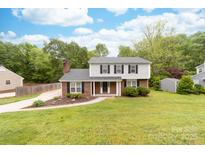 Charming two-story home with brick and vinyl siding, a well-manicured lawn, and mature trees at 616 Silversmith Ln, Charlotte, NC 28270