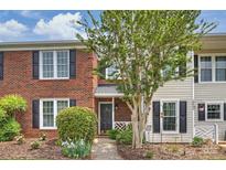 Charming brick townhome featuring a landscaped front yard and a welcoming entrance at 10943 Winterbourne Ct, Charlotte, NC 28277