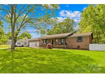 Charming single-story brick home with a well-manicured lawn, attached garage, and inviting front porch at 1279 Rocky Creek Rd, Shelby, NC 28152