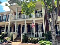 Charming two-story brick home with a double porch and an American flag on display at 172 Harper Lee St, Davidson, NC 28036