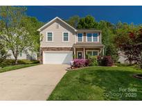 Charming two-story home featuring stone accents, a well-manicured lawn, and a spacious driveway at 246 Mallard Head Dr, Rock Hill, SC 29732