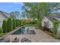 Inviting in-ground pool with patio seating and lush landscaping provides a private outdoor retreat at 309 Catawba Ave, Davidson, NC 28036