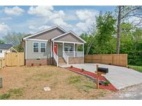 Charming home with a red front door, a welcoming porch, and a well-maintained front yard at 320 Evans Nw St, Concord, NC 28027