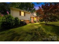 Charming split level home with lush landscaping and a well-manicured lawn at 4901 White Oak Rd, Charlotte, NC 28210