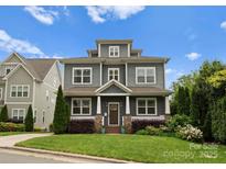 Charming two-story home featuring gray siding, manicured lawn and beautifully landscaped yard, creating excellent curb appeal at 615 Welker St, Charlotte, NC 28204