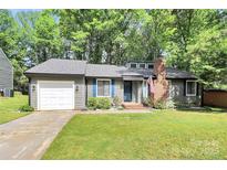 Charming single-story home with gray siding, brick chimney, mature trees, and a well-manicured front lawn at 6712 Santa Maria Ln, Charlotte, NC 28227