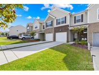 Charming townhomes feature brick accents, attached garages, and manicured lawns at 7004 Everly Commons Ln, Tega Cay, SC 29708