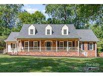 Charming red brick home featuring a welcoming front porch and well-maintained lawn at 781 Summerwood Dr, Rock Hill, SC 29732