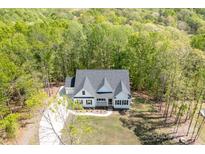 Stunning aerial view of a home nestled among a lush, green forest with long driveway at 131 High Lake Dr, Statesville, NC 28677