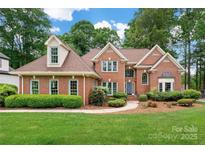 Charming brick home with well-manicured lawn, lush landscaping and inviting entrance at 15535 Eagleview Dr, Charlotte, NC 28278
