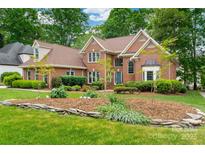 Charming two-story red brick home featuring a well-manicured lawn and beautiful landscaping at 15535 Eagleview Dr, Charlotte, NC 28278