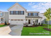 Charming two-story home featuring a covered porch, two-car garage, and manicured lawn at 203 Batten Ridge Dr # 313, Statesville, NC 28677