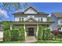 Charming two-story home with a covered front porch, manicured lawn, and lush landscaping at 2841 Attaberry Dr, Charlotte, NC 28205