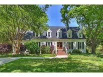 Charming home featuring a manicured lawn and brick entryway, framed by mature trees at 4501 Montibello Dr, Charlotte, NC 28226