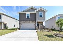 Charming two-story home featuring stone accents, neutral siding, a two-car garage, and manicured landscaping at 5017 Poplin Vly, Cherryville, NC 28021