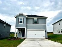 Charming two-story home features a two-car garage, beautiful landscaping, and a welcoming front entrance at 5018 Poplin Vly, Cherryville, NC 28021