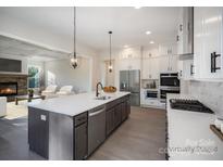 A kitchen with stainless steel appliances, a large island, and white cabinetry provides a sleek aesthetic at 515 Edmunds Ln, Clover, SC 29710