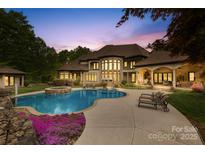 Luxury home showcasing a beautiful pool, spa, and outdoor lounge area with manicured landscaping at 8451 Ridgewood Rd, Sherrills Ford, NC 28673