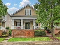 Charming home featuring a welcoming front porch with classic columns and a well-maintained front yard at 9640 Alma Blount Blvd, Charlotte, NC 28277