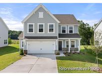 Charming two-story home featuring gray siding, a two-car garage, and well-manicured lawn at 106 Jetty Ln # 472, Statesville, NC 28677