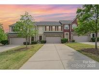 Inviting townhouse showcasing a well-manicured lawn and attached garages against a beautiful sky at 1849 Fleetwood Dr, Charlotte, NC 28208