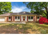 Charming single-story home featuring red shutters, brick accents, a well-maintained yard, and a beautiful red azalea bush at 2007 Green Peach Rd, Lancaster, SC 29720