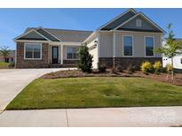 Charming single-story home boasts manicured lawn and stylish stone accents on the facade at 2081 Fordhill St, Rock Hill, SC 29732
