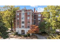 A brick apartment building with classic architectural details, surrounded by lush greenery at 301 W 10Th St # 402, Charlotte, NC 28202