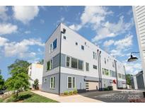 Modern, multi-story home featuring contemporary siding, large windows, and an attached garage under a partly cloudy sky at 302 Wesley Heights Way, Charlotte, NC 28208
