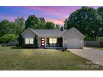 Charming single story home boasts a lovely landscaped yard, inviting front porch, and attached garage at 308 Southland Rd, Huntersville, NC 28078
