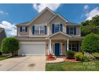 Charming two-story home featuring blue shutters, a well-manicured lawn, and a two-car garage at 461 Pier Point Nw Ct, Concord, NC 28027