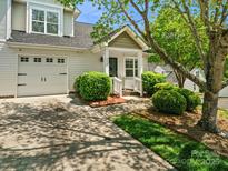 Charming home exterior featuring a one-car garage, lush landscaping, and a welcoming front porch at 6647 Vlosi Dr, Charlotte, NC 28226