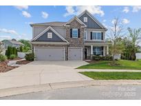 Charming two-story home with stone accents, a three-car garage, and well-maintained landscaping at 106 Wrangler Dr, Mooresville, NC 28115