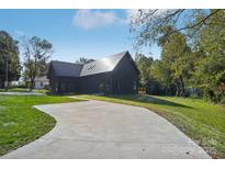 Stunning modern home with metal roof, expansive driveway, and lush green lawn at 122 Laura Rd # A, Mooresville, NC 28117