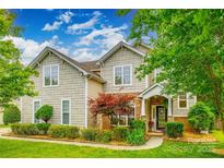 Inviting two-story home featuring stone accents, manicured lawn, and mature landscaping at 1418 Lonan Dr, Waxhaw, NC 28173