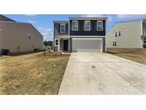 Two-story home with a two-car garage, concrete driveway, and a well-manicured lawn at 250 Marinna Joy Cir, Rockwell, NC 28138