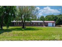 Charming brick ranch home with metal roof, mature tree, and a detached garage at 4815 Rifle Range Rd, Conover, NC 28613