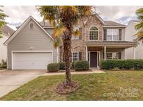 Charming two-story home with stone accents, a well-manicured lawn, and a two-car garage at 5707 Parkstone Dr, Matthews, NC 28104