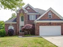 Charming two-story brick home with manicured lawn and attached two-car garage at 7642 Horseshoe Creek Dr, Huntersville, NC 28078