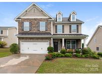 Charming two-story home featuring a stone facade, manicured landscaping, and an attached two-car garage at 79044 Ridgehaven Rd, Lancaster, SC 29720