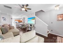 Bright living area with a large television, open layout, and staircase in view at 8814 Gerren Ct, Charlotte, NC 28217