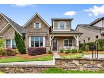 Charming brick home featuring a cozy front porch and professionally landscaped front yard at 9319 Highclere Ct, Matthews, NC 28105