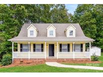 Charming yellow home featuring a welcoming front porch, black shutters and dormer windows at 1930 Manning Pl, Rock Hill, SC 29730